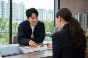 청약 안내 서류를 확인하며 상담받는 장면